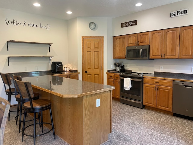 26780 Packard St NE, Athens Twp, MN 55040 - kitchen featuring appliances with stainless steel finishes, open shelves, a kitchen bar, a peninsula, and brown cabinetry