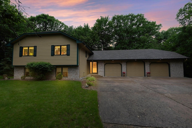 9855 Kadler Ave NE, Otsego, MN 55362 - split level home with concrete driveway, an attached garage, a yard, and brick siding