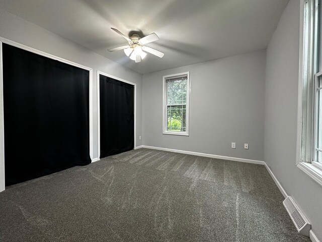 13805 Central Ave, Becker, MN 55308 - unfurnished bedroom featuring two closets, dark carpet, and a ceiling fan