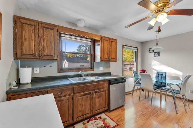 5215 Washburn Ave N, Minneapolis, MN 55430 - kitchen featuring stainless steel dishwasher, brown cabinets, dark countertops, light wood-type flooring, and ceiling fan