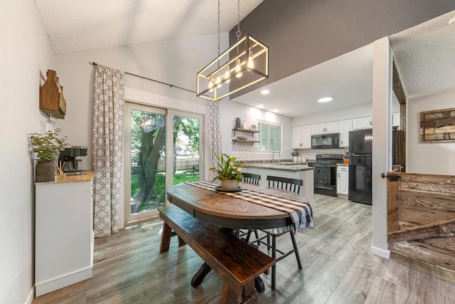 2585 3rd Ave NE, Owatonna, MN 55060 - dining space featuring light wood-style flooring, lofted ceiling, and a chandelier