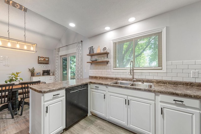 2585 3rd Ave NE, Owatonna, MN 55060 - kitchen with black dishwasher, light wood finished floors, vaulted ceiling, white cabinetry, and backsplash