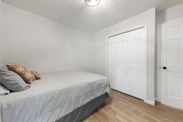 2585 3rd Ave NE, Owatonna, MN 55060 - bedroom with light wood finished floors, a textured ceiling, and a closet