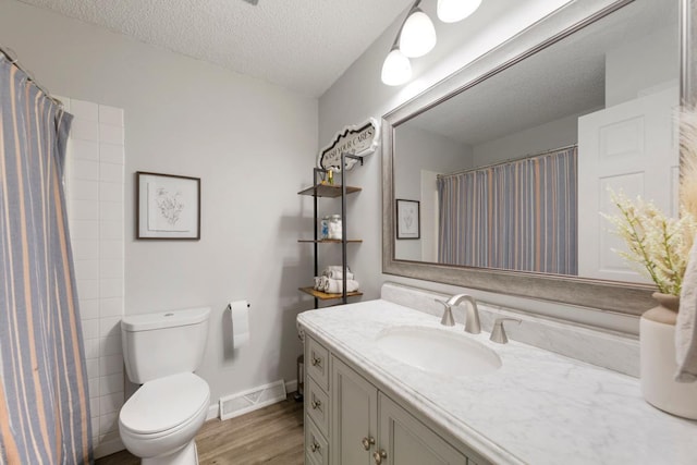 2585 3rd Ave NE, Owatonna, MN 55060 - bathroom with vanity, wood finished floors, a textured ceiling, and curtained shower