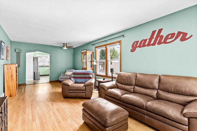 28 16th St, Cloquet, MN 55720 - living room with arched walkways, light wood-style flooring, and a ceiling fan
