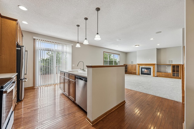 6773 Urbandale Ln N, Maple Grove, MN 55311 - kitchen featuring stainless steel appliances, hardwood / wood-style flooring, a textured ceiling, pendant lighting, and brown cabinets