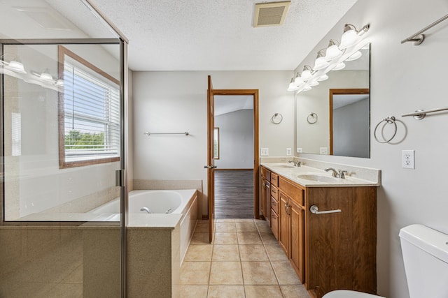 6773 Urbandale Ln N, Maple Grove, MN 55311 - bathroom with a bath, double vanity, a shower stall, a textured ceiling, and tile patterned flooring