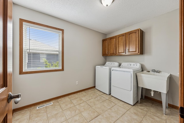 6773 Urbandale Ln N, Maple Grove, MN 55311 - laundry area with washer and dryer, cabinet space, a textured ceiling, and light tile patterned floors