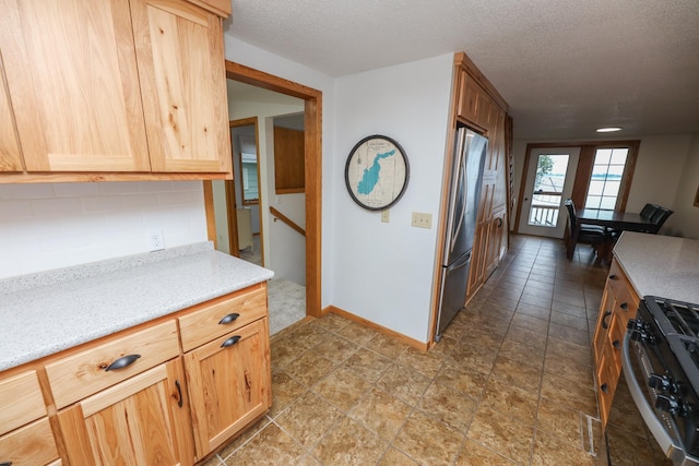 17 Lake St, Osakis, MN 56360 - kitchen with stainless steel appliances, backsplash, a textured ceiling, light stone countertops, and light brown cabinetry