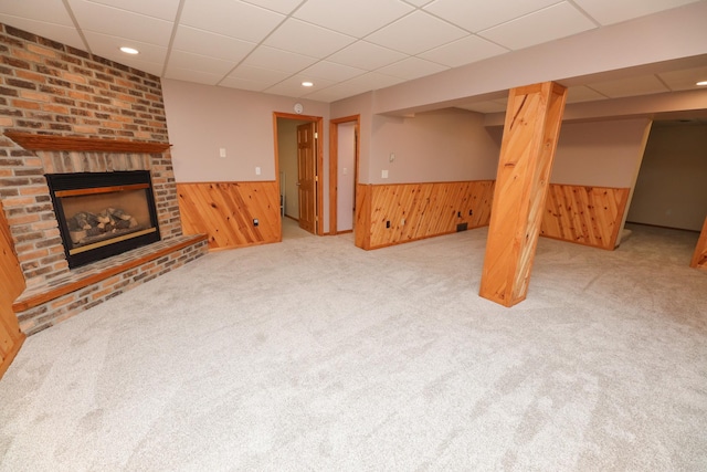 17 Lake St, Osakis, MN 56360 - unfurnished living room with a wainscoted wall, wooden walls, a drop ceiling, carpet floors, and a brick fireplace