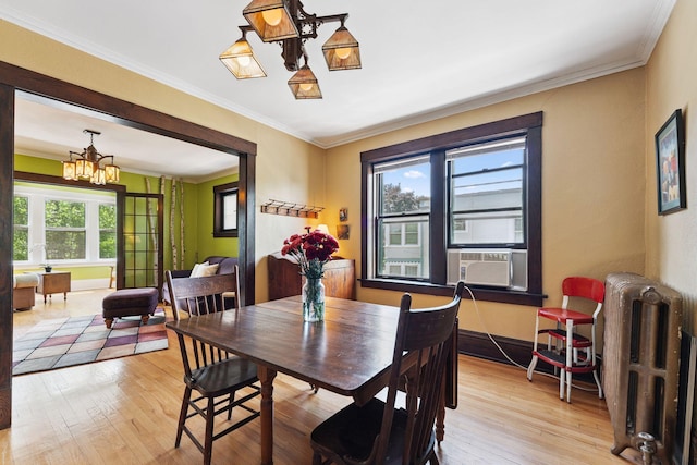 1725 Hague Ave Unit 4, Saint Paul, MN 55104 - dining area featuring radiator, light wood finished floors, a chandelier, cooling unit, and ornamental molding