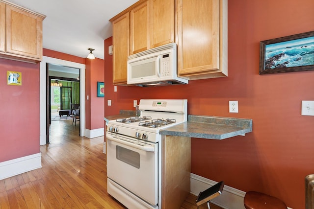 1725 Hague Ave Unit 4, Saint Paul, MN 55104 - kitchen featuring white appliances, light wood-style flooring, and dark countertops