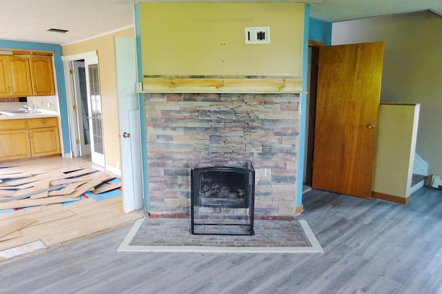 2332 7th St, Superior, WI 54880 - unfurnished living room featuring light wood-type flooring, a fireplace with flush hearth, and crown molding