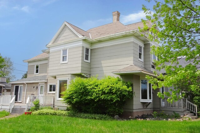2332 7th St, Superior, WI 54880 - rear view of house featuring a chimney, a yard, a wooden deck, and a shingled roof
