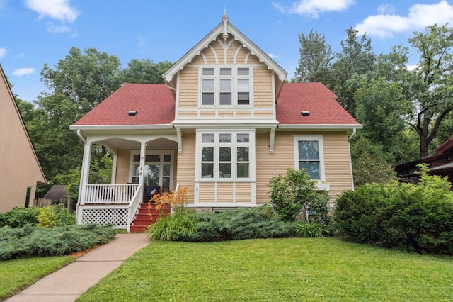 2145 Knapp St, Saint Paul, MN 55108 - view of front facade with a porch, a front lawn, and a shingled roof