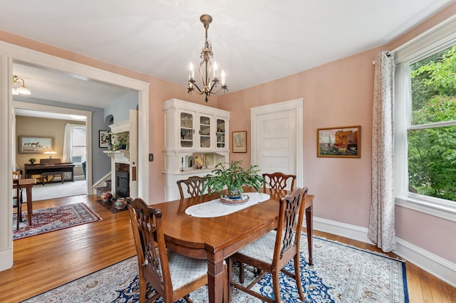 2145 Knapp St, Saint Paul, MN 55108 - dining space with a chandelier, light wood finished floors, and a fireplace