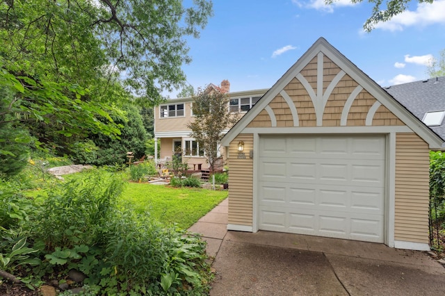 2145 Knapp St, Saint Paul, MN 55108 - view of front of house with concrete driveway, a garage, a shingled roof, and a chimney