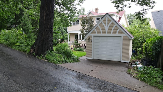 2145 Knapp St, Saint Paul, MN 55108 - view of front of property with driveway, a garage, a chimney, and an outbuilding