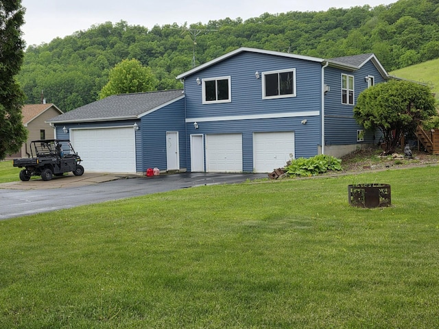 S3527 Bobcat Trl, Buffalo Twp, WI 54629 - view of front of home with a front lawn, a wooded view, driveway, and a shingled roof