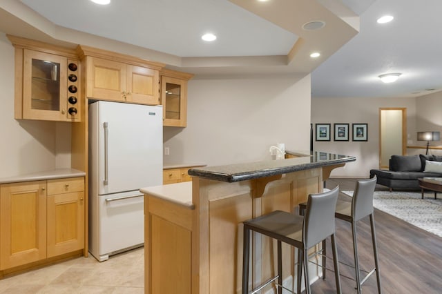 3933 Donegal Way, Eagan, MN 55122 - kitchen featuring freestanding refrigerator, a kitchen breakfast bar, open floor plan, recessed lighting, and glass insert cabinets