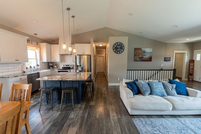 695 Marcus Pl NE, Byron, MN 55920 - kitchen featuring appliances with stainless steel finishes, vaulted ceiling, dark wood-type flooring, white cabinetry, and a center island