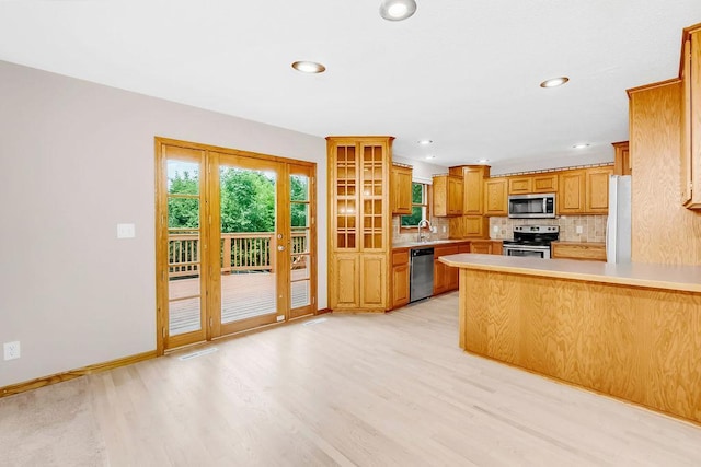 1420 17th St W, Hastings, MN 55033 - kitchen with stainless steel appliances, light wood-type flooring, backsplash, a peninsula, and light countertops