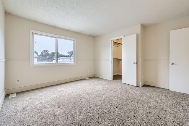 455 107th Ln NW, Coon Rapids, MN 55448 - unfurnished bedroom featuring carpet floors, a textured ceiling, a spacious closet, and a closet
