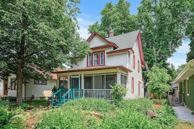 3231 41st Ave S, Minneapolis, MN 55406 - victorian home featuring a chimney, a sunroom, and roof with shingles