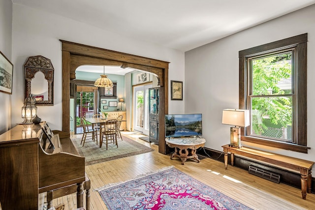 3231 41st Ave S, Minneapolis, MN 55406 - living room with wood-type flooring, healthy amount of natural light, arched walkways, and a chandelier