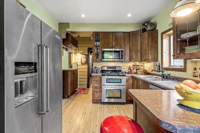 3231 41st Ave S, Minneapolis, MN 55406 - kitchen with stainless steel appliances, light wood-style flooring, dark countertops, glass insert cabinets, and recessed lighting