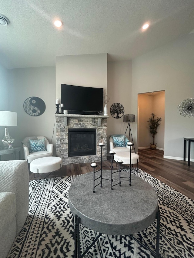 8756 151st Ave NW, Ramsey, MN 55303 - living room featuring wood finished floors, a stone fireplace, a textured ceiling, and recessed lighting