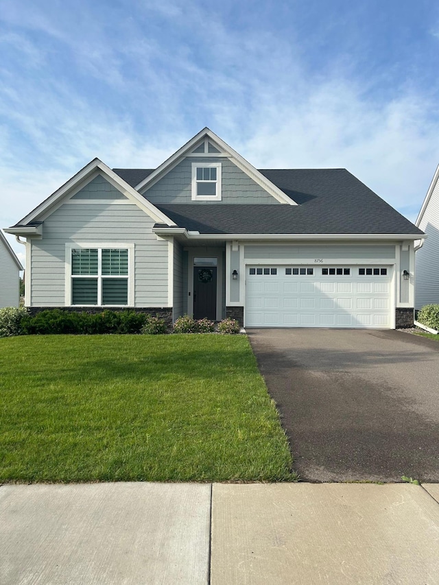 8756 151st Ave NW, Ramsey, MN 55303 - craftsman-style home featuring driveway, an attached garage, a front lawn, and stone siding