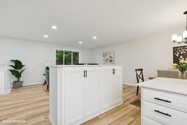9019 Idaho Ave N, Brooklyn Park, MN 55445 - kitchen with light wood finished floors, white cabinets, a chandelier, recessed lighting, and light countertops