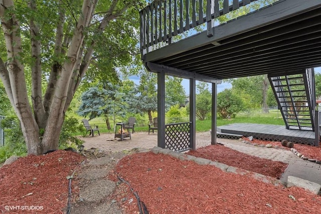 9019 Idaho Ave N, Brooklyn Park, MN 55445 - view of yard featuring a fire pit, a patio, stairway, and a wooden deck