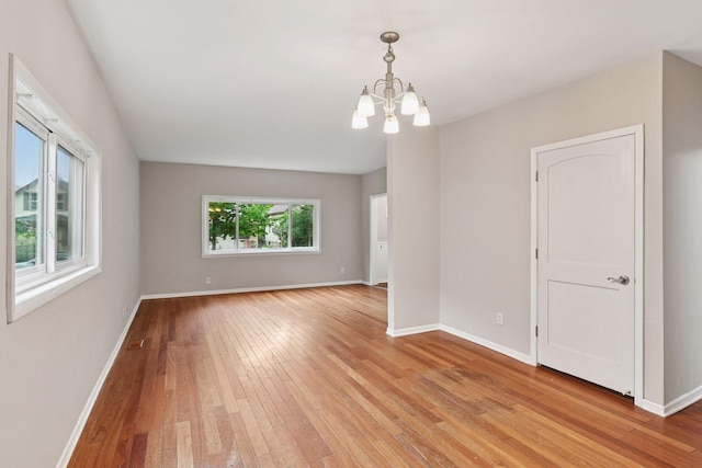 724 Pierce St NE, Minneapolis, MN 55413 - empty room with light wood-style flooring and a chandelier