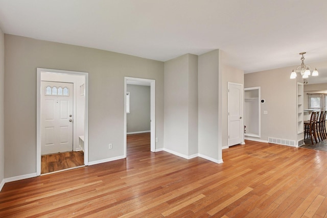 724 Pierce St NE, Minneapolis, MN 55413 - unfurnished living room with a chandelier and light wood finished floors