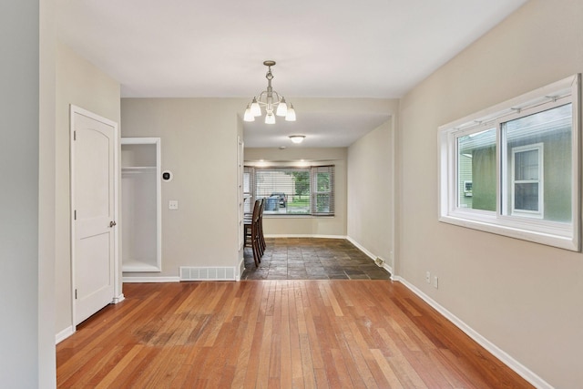 724 Pierce St NE, Minneapolis, MN 55413 - unfurnished dining area with wood-type flooring and a chandelier