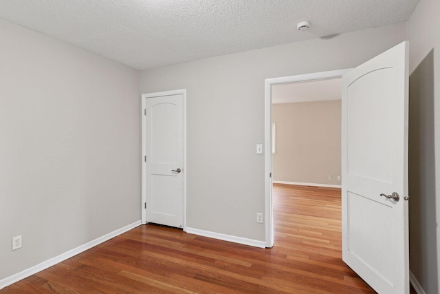 724 Pierce St NE, Minneapolis, MN 55413 - unfurnished room with wood finished floors, a smoke detector, and a textured ceiling