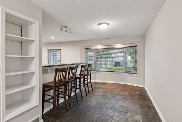 724 Pierce St NE, Minneapolis, MN 55413 - dining space featuring stone tile floors and a textured ceiling