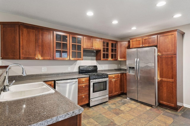 724 Pierce St NE, Minneapolis, MN 55413 - kitchen with appliances with stainless steel finishes, recessed lighting, stone tile flooring, glass insert cabinets, and dark countertops