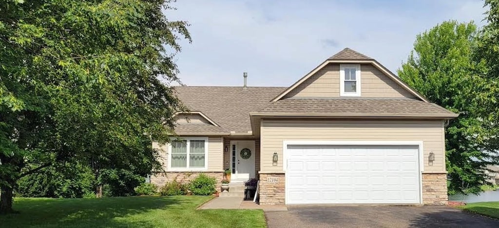 12104 Bataan St NE, Blaine, MN 55449 - craftsman-style house featuring driveway, stone siding, and a front yard