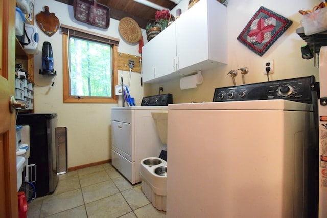 28716 Kilkare Rd, Danbury, WI 54830 - laundry area featuring independent washer and dryer, cabinet space, and light tile patterned floors