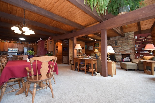 28716 Kilkare Rd, Danbury, WI 54830 - carpeted dining area with a chandelier, wooden ceiling, an outdoor stone fireplace, and wood walls