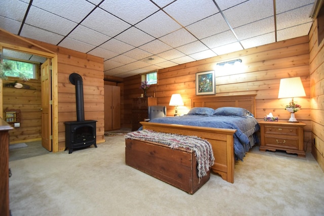28716 Kilkare Rd, Danbury, WI 54830 - bedroom featuring wood walls, light carpet, and a wood stove