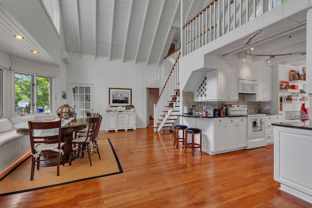13188 Chicago Club Ln NE, Alexandria, MN 56308 - dining area featuring high vaulted ceiling, stairway, light wood-style floors, and beamed ceiling