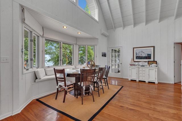 13188 Chicago Club Ln NE, Alexandria, MN 56308 - dining area featuring light wood-style floors, high vaulted ceiling, a wall mounted air conditioner, and a wooden ceiling with exposed beams