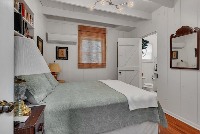 13188 Chicago Club Ln NE, Alexandria, MN 56308 - bedroom with a wall mounted air conditioner, wood finished floors, beamed ceiling, connected bathroom, and wooden walls