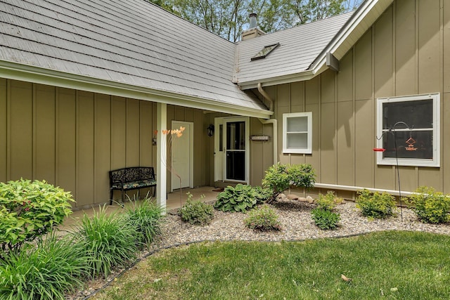 13188 Chicago Club Ln NE, Alexandria, MN 56308 - view of exterior entry with board and batten siding, a chimney, and a yard