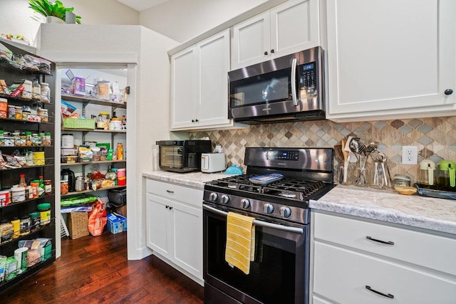 1115 Timber Path, Menomonie, WI 54751 - kitchen with stainless steel microwave, gas range oven, backsplash, and dark wood finished floors