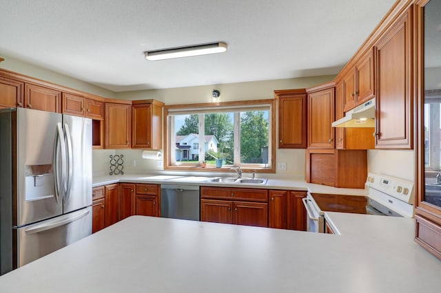 205 4th St NW, Saint Michael, MN 55376 - kitchen with appliances with stainless steel finishes, under cabinet range hood, light countertops, and brown cabinetry